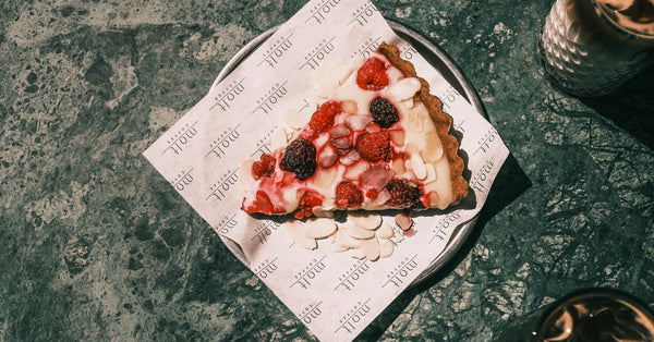 Top view of a delicious berry tart slice with cream on a plate, perfect for a dessert treat.