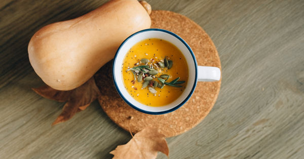 A cozy autumn-inspired pumpkin soup garnished with seeds, perfect for fall meals.