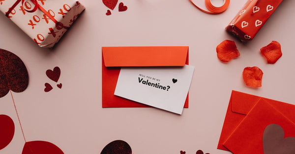 A heartwarming Valentine's Day setup with a card, envelope, and red decorations.
